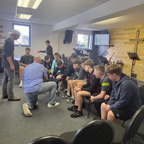 Youth group meeting with a leader praying